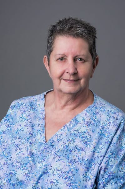 Senior resident with short hair and blue top.