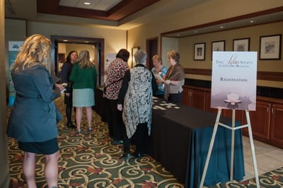 Guests registering at a formal event in a lobby.