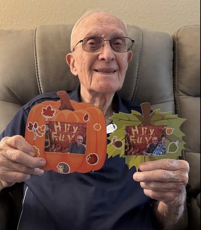 Resident holding autumn-themed decorations.