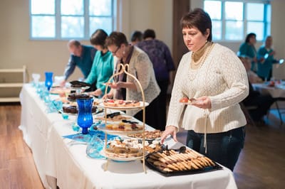 Guests enjoying a dessert buffet at a social event.