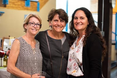 Three smiling women at an event