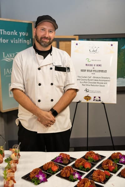 Chef showcasing a food display with dishes.