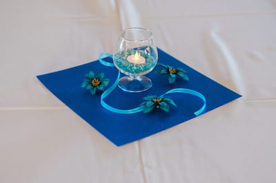 Decorative table centerpiece with candle and flowers.