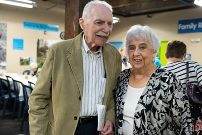 Two smiling seniors in a communal space
