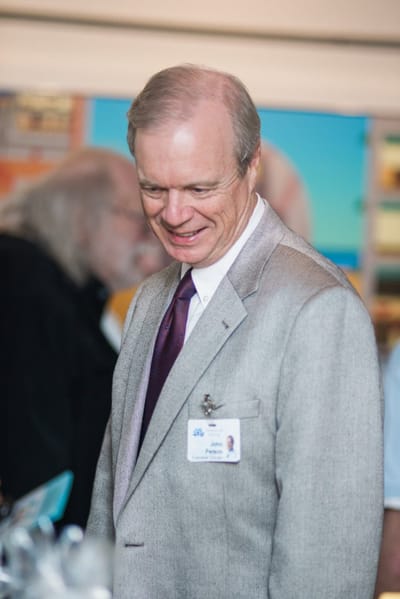 Man smiling at an event with name badge.