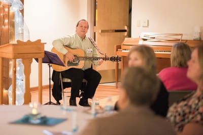 Musician performing for residents in a common area.