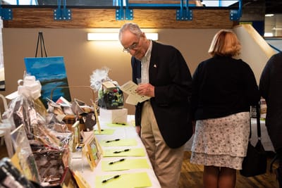 An older man reading a brochure at an event.