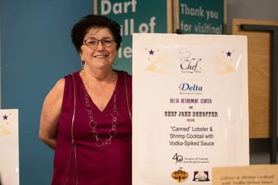 Woman presenting a cooking event poster.