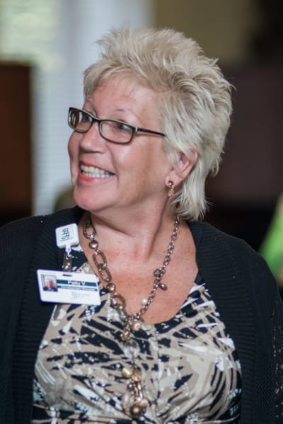 Smiling staff member with a name badge