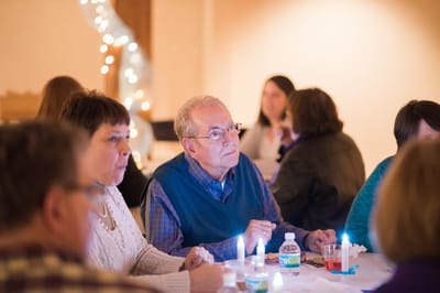 Residents engaged in a gathering with soft lighting.