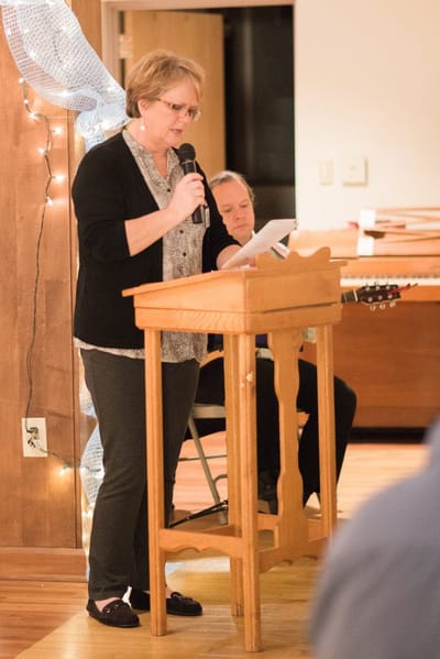 Woman speaking into a microphone at an event.