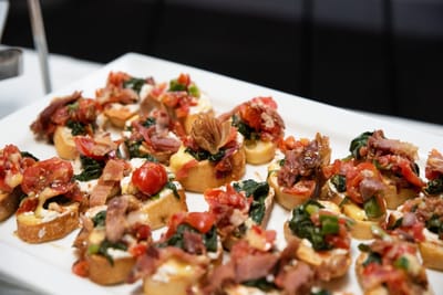 Platter of gourmet appetizers with toppings.