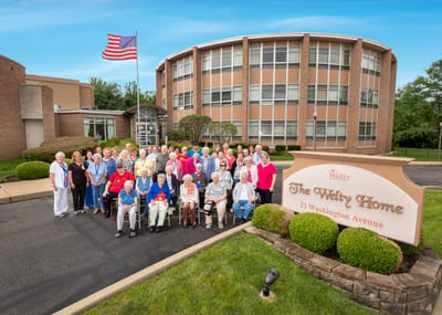 Group photo of residents and staff outside the Welty Home