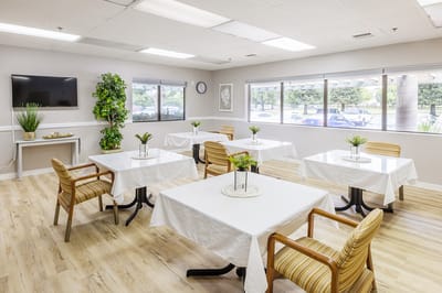 Bright dining room with tables set for residents