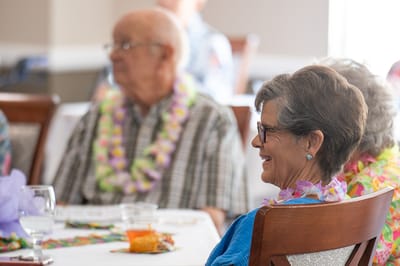 Residents enjoying a social gathering with leis
