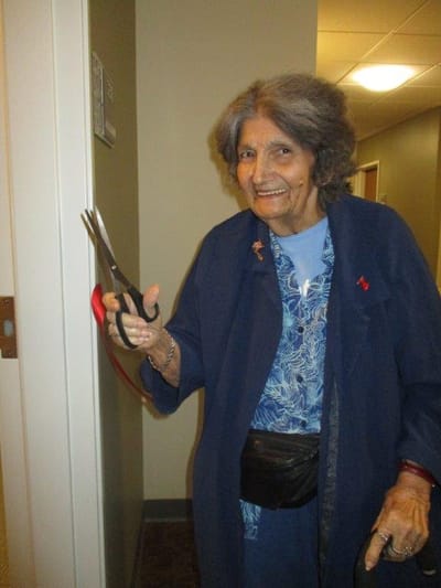 Resident holding scissors in a hallway