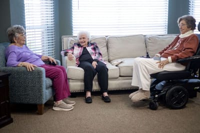 Three residents enjoying conversation in a cozy living room