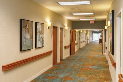 A well-lit corridor with framed artwork on the walls