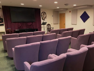 Interior view of a cozy activity room with purple chairs