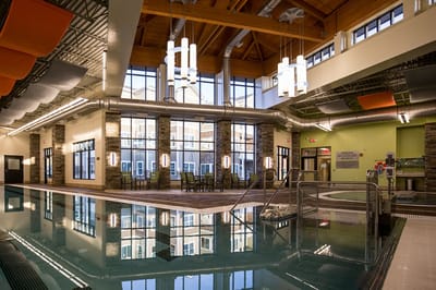 Indoor pool area with large windows and seating