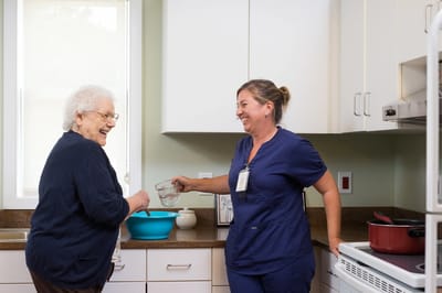 Caregiver and resident enjoying cooking together in kitchen