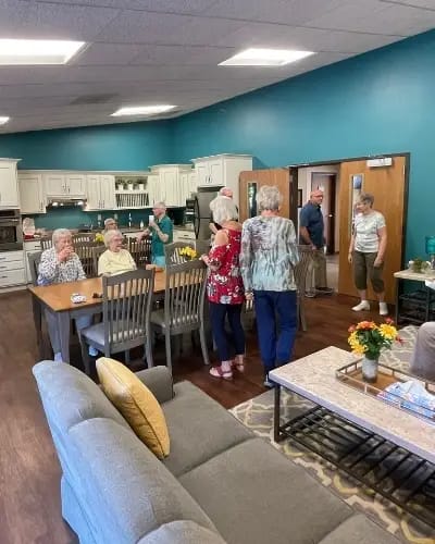 Residents and staff interacting in a common area lounge
