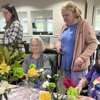 Residents and staff engaged in flower arranging activity