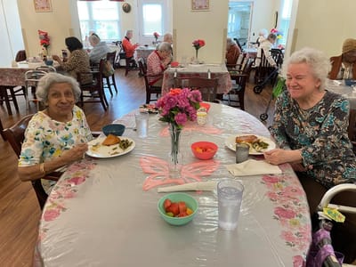 Residents enjoying lunch at a communal dining table.