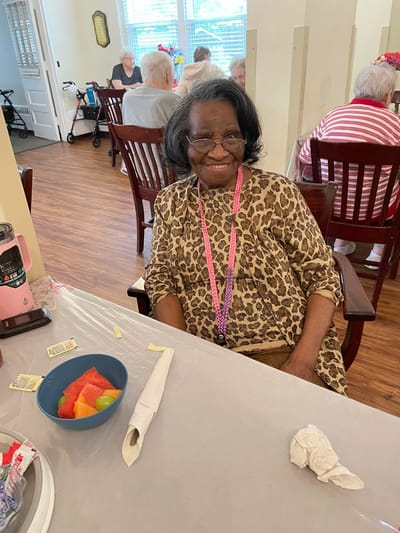 A resident enjoying fresh fruit in a social setting