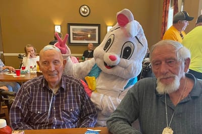 Resident celebration with a mascot in the dining area