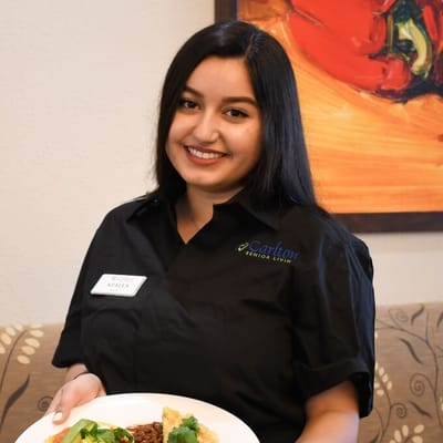 Staff member presenting a meal in the facility's dining room