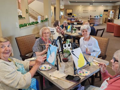 Residents participating in a painting activity in the common area