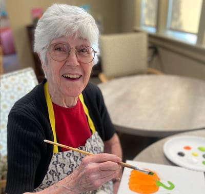 Resident painting a pumpkin during an activity session