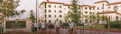 Exterior view of Grand Living at Tuscan Lakes with residents and staff