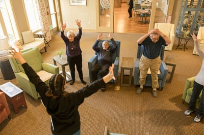 Residents participating in a seated exercise class