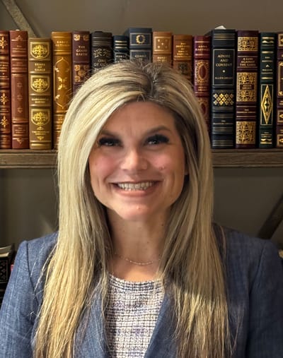 Professional staff member smiling in a cozy library setting