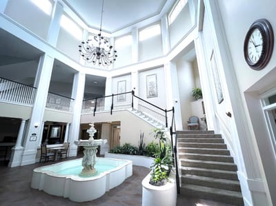 Interior view of a bright common area with stairs and fountain