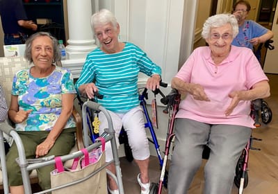 May River Landing, assisted living in Bluffton, SC — Three smiling elderly women in mobility aids