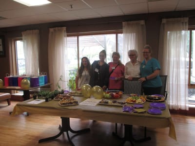 Staff members at a celebration with food and decor