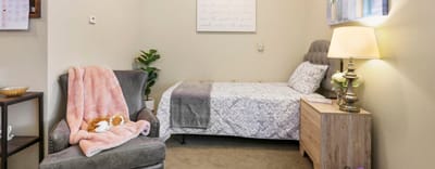 Cozy private resident room with a bed and chair