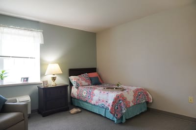 Cozy resident room with bed and lamp