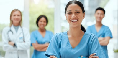 Healthcare staff smiling together in a bright room