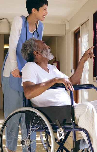 A caregiver assisting a resident in a hallway