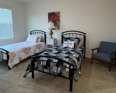 A cozy resident room with two beds and a chair