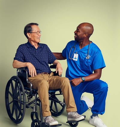 Healthcare worker interacting with a resident in a wheelchair