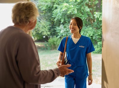 Caregiver greeting a resident at the door