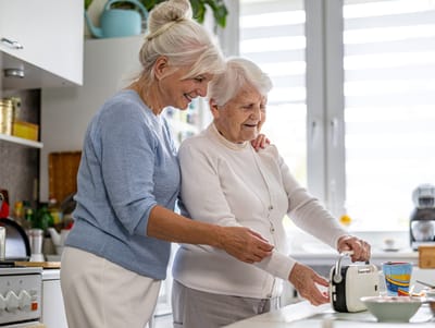Caregiver assisting senior in a kitchen