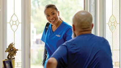 Staff member greeting a resident at the door