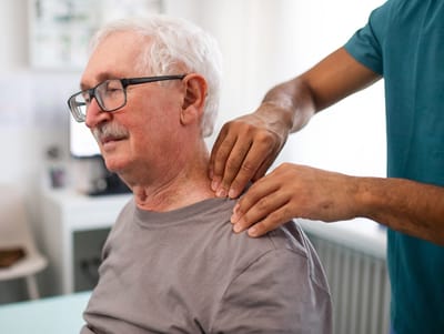 Staff assisting a resident with a shoulder massage