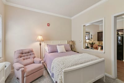 Cozy resident room with a bed and armchair